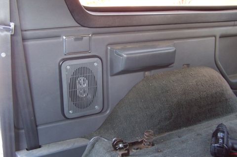 1990 Ford Bronco - Interior view of a vehicle's rear passenger side panel with a speaker and seatbelt visible.