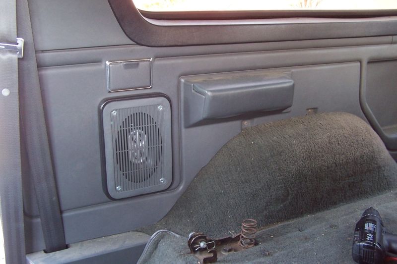 Interior panel with speaker, seatbelt, and carpeted hump