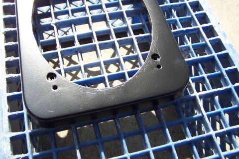 1990 Ford Bronco - Speaker adapter bracket on a blue plastic grid.
