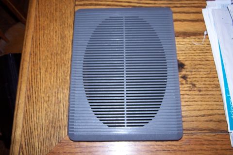 1990 Ford Bronco - A gray speaker adapter with a distinctive horizontal grille pattern is shown on a wooden surface.