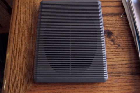 1990 Ford Bronco - Speaker adapter part shown on a wooden table.