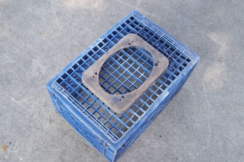 1990 Ford Bronco - A wooden speaker adapter rests on a blue plastic crate, viewed from above.