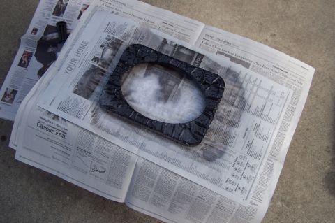 1990 Ford Bronco - Spray painting a speaker adapter on top of old newspapers.