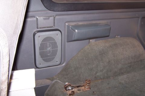 1990 Ford Bronco - A close-up view of the interior of a vehicle, showing a speaker and carpeted carpet.