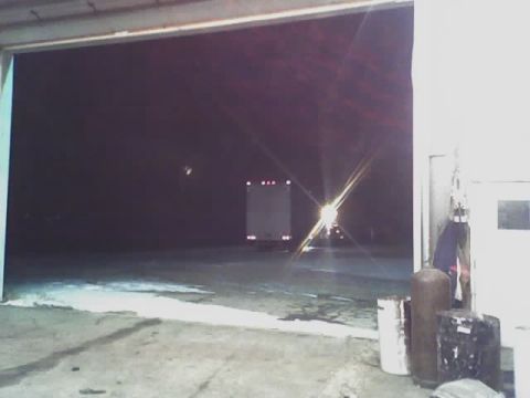 1992 Ford Bronco - A white box truck is seen from behind as it exits a garage in the dark.