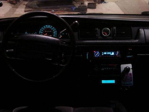 1992 Ford Crown Victoria - The interior of a car shows a dashboard with illuminated gauges and an aftermarket stereo system.
