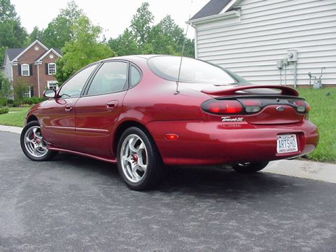 1998 Ford Taurus - This red sedan has a spoiler and a license plate that reads 'ARTSHO'.