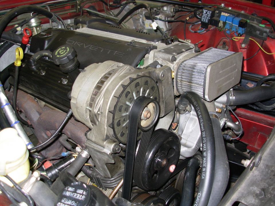 LS V8 swap with Corvette-branded cam cover, alternator and finned airbox in a red engine bay