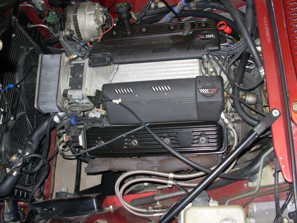 Corvette engine bay with black valve covers and 'CORVETTE' lettering on intake manifold covers