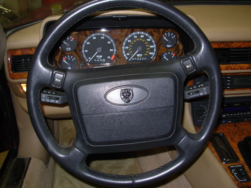Black Jaguar steering wheel with growler badge, wood dash and gauge cluster showing 78,200 miles