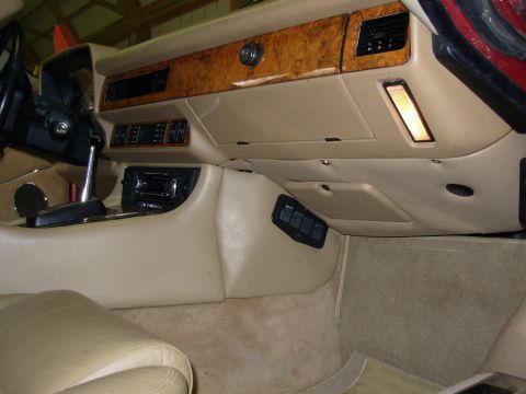1992 Jaguar XJ-S - The dashboard and center console of a classic car are shown, wood grain accents and beige upholstery.