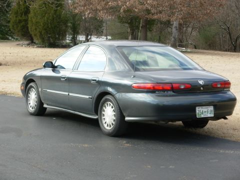 1999 Mercury Sable - This 1999 Mercury Sable is shown from the rear, parked on an asphalt surface with trees in the background.