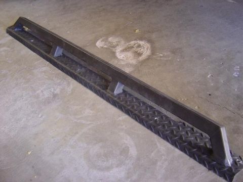 1986 Ford Bronco II - A single running board with diamond plate texture and a metal support bar is shown on a concrete surface.