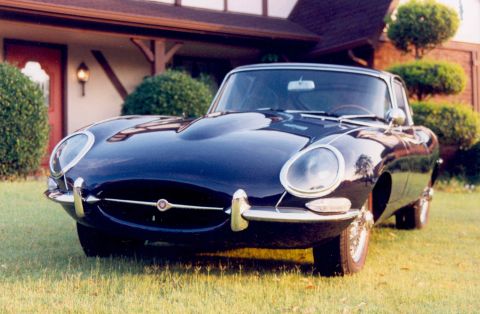 1967 Jaguar XKE - A classic 1967 Jaguar XKE Series 1 coupe is shown from the front, parked on a lawn.