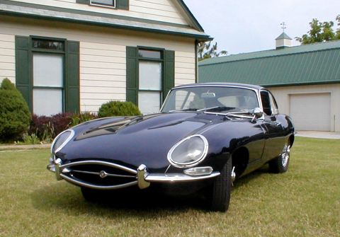 1967 Jaguar XKE - A 1967 Jaguar XKE coupe is seen from a three-quarter front view on a grassy lawn.