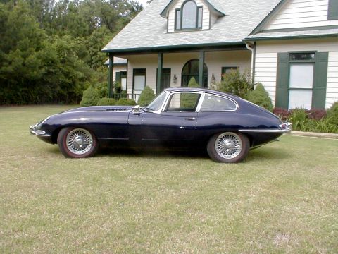 1967 Jaguar XKE - Side view of a 1967 Jaguar XKE coupe parked on a grassy lawn in front of a house.