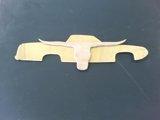 Wooden cutout of a pickup truck with a longhorn skull overlay