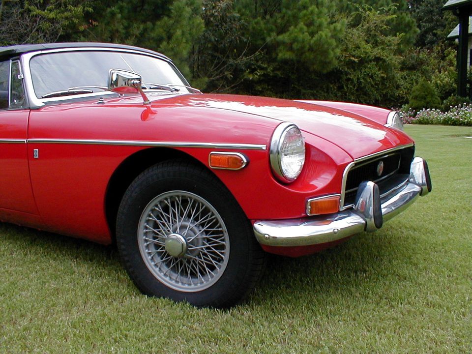 Red MG B convertible front corner with chrome wire wheel and bumper on grass
