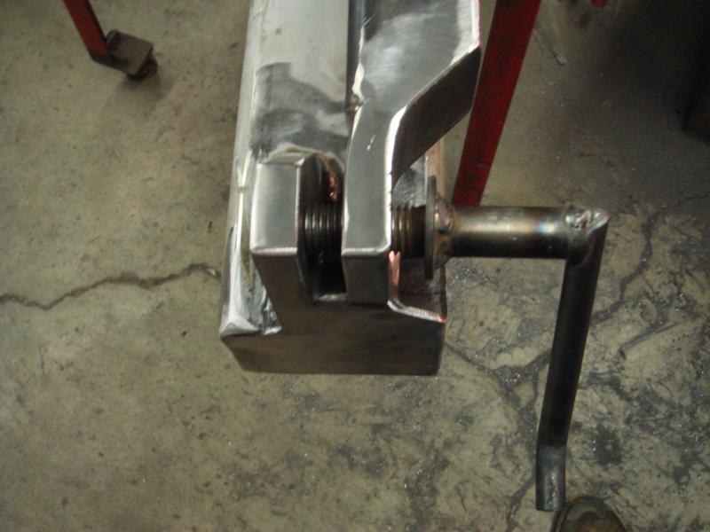 Metal clamp with threaded rod and handle, on concrete floor