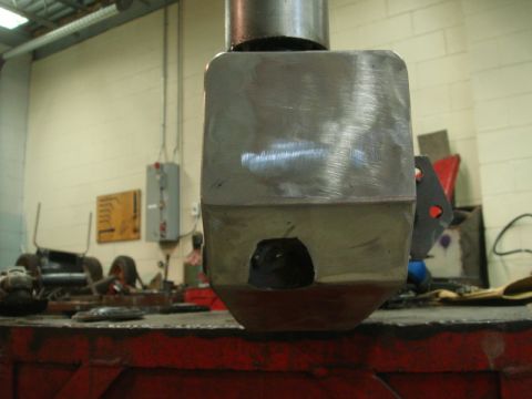 1996 Ford Bronco - A close-up view of a metal component with a hole, likely undergoing fabrication or repair.