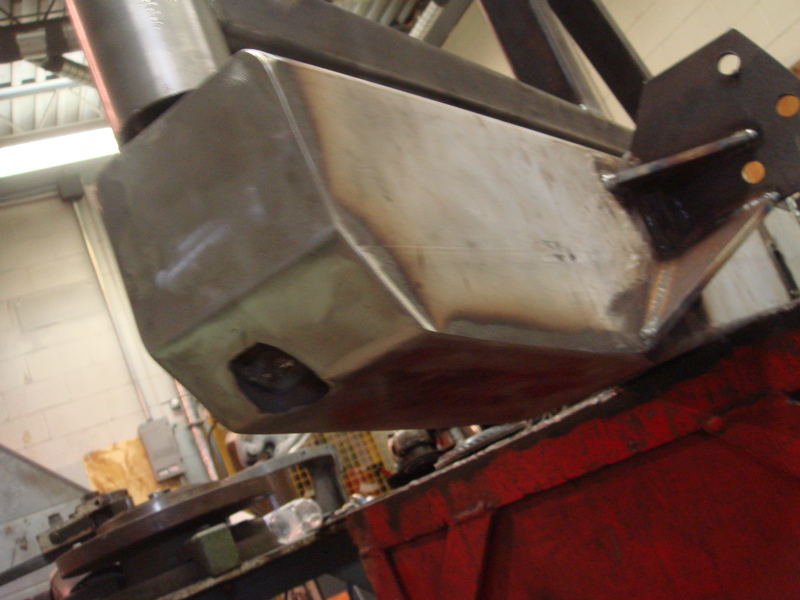 Close-up of a fabricated metal rear bumper with welded seams and a cut-out