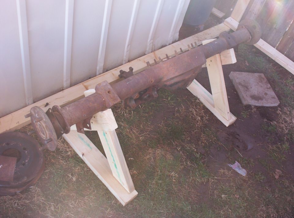 rusty vehicle axle on wooden stands