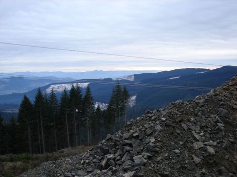 1996 Ford Bronco - A scenic view of a mountain range under a cloudy sky, with a rocky slope in the foreground.