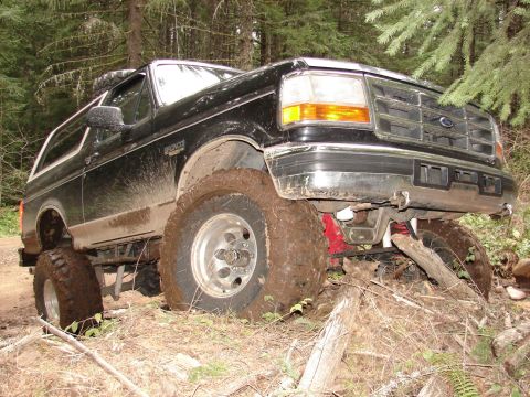 1996 Ford Bronco - This lifted 1996 Ford Bronco navigates a muddy, wooded trail, its off-road capabilities.