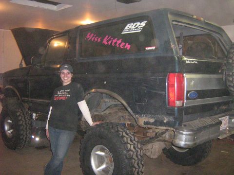 1995 Ford Bronco - A woman poses with a modified Ford Bronco, which appears to be from the early 1990s.
