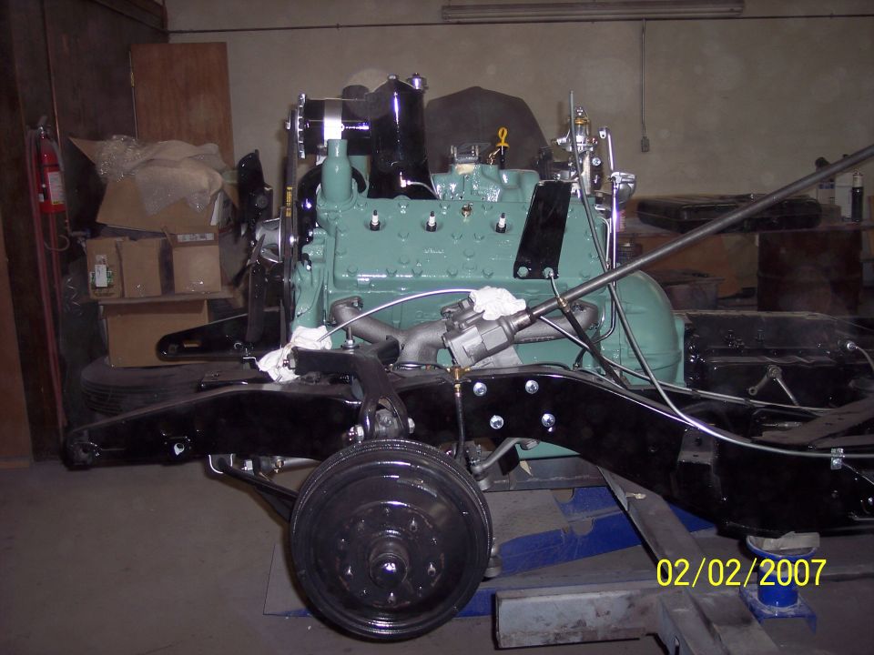 Pale-green rebuilt engine mounted in a black restored frame with front drum brake