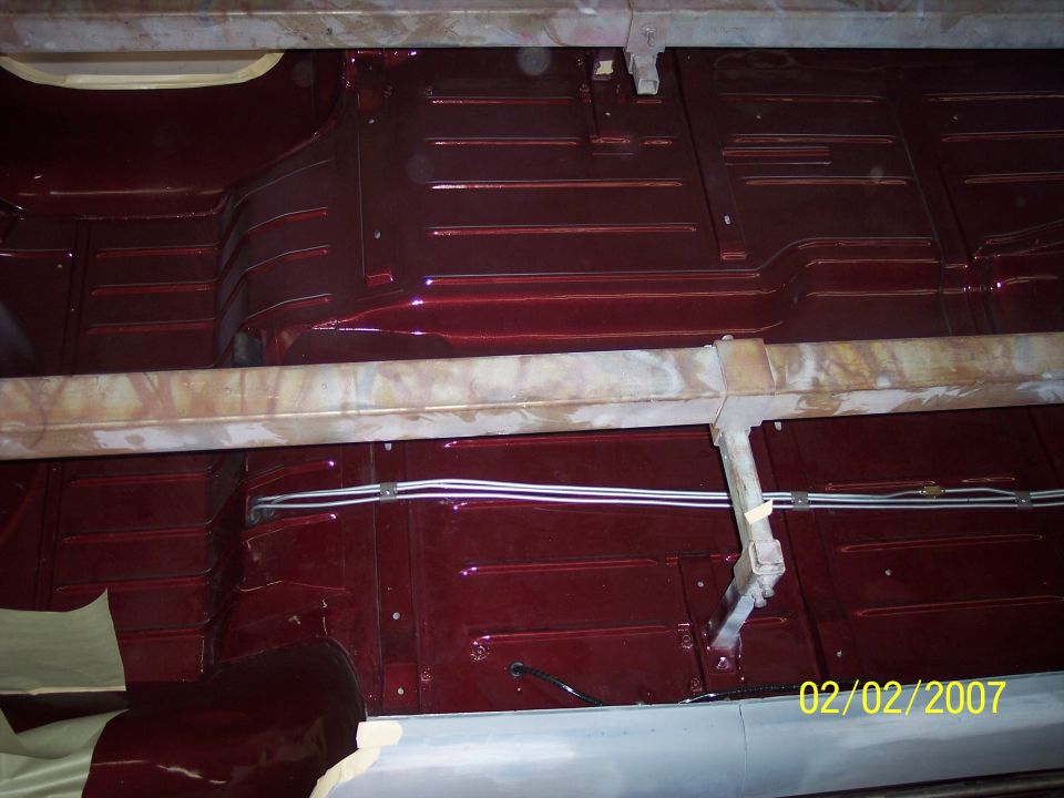 Glossy maroon painted floor pan and transmission tunnel with new brake lines