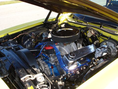 1979 Ford Ranchero - The engine bay of a yellow vehicle reveals a powerful Ford Racing V8 engine with custom blue wiring.
