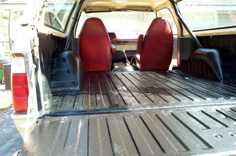 1978 Dodge Power Ram - Interior view of a 1978 Dodge Power Ram pickup truck, highlighting the red seats and bed liner.