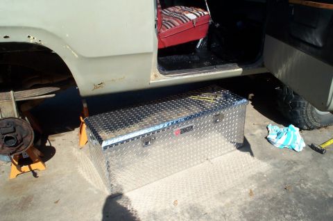 1978 Dodge Power Ram - A diamond plate toolbox is positioned next to the open door of a truck, revealing its interior and striped seat.