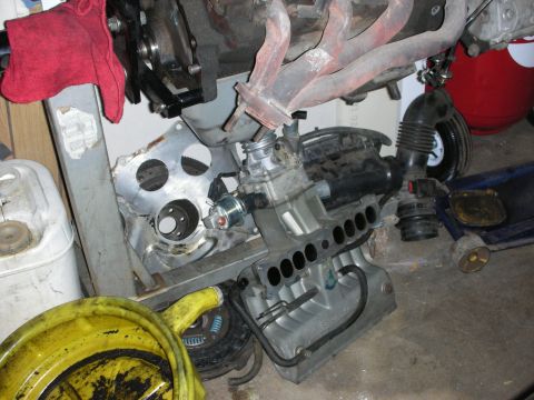 1990 Ford Mustang - Engine components, including a block, intake manifold, and exhaust headers, are shown in a workshop setting.