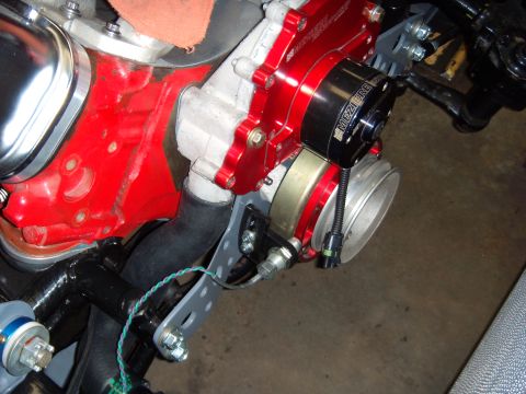 1984 Ford Bronco - Aftermarket red aluminum water pump and pulley assembly mounted on an engine.