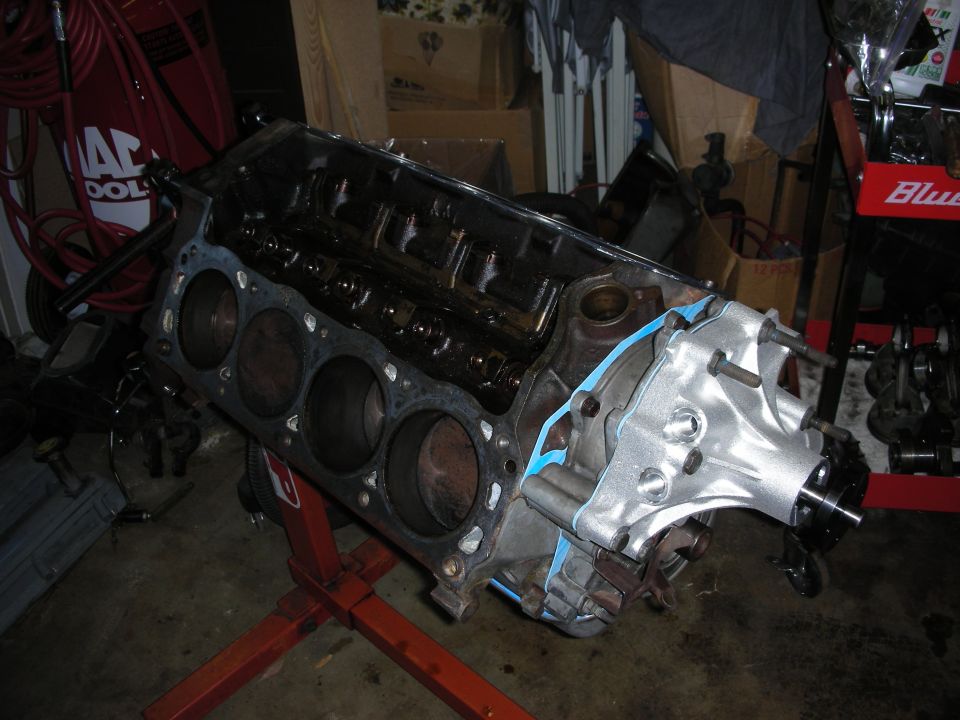 Engine block on a red stand, with gasket material visible