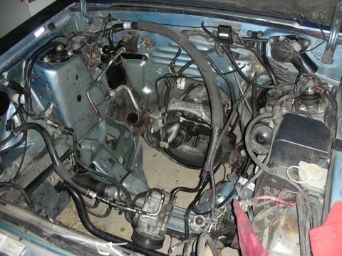 1990 Ford Mustang - View of the engine bay, showing the transmission and various hoses and wiring.