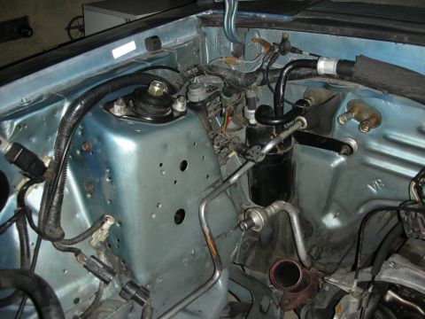 1990 Ford Mustang - Close-up view of engine bay components including AC lines and strut tower assembly.