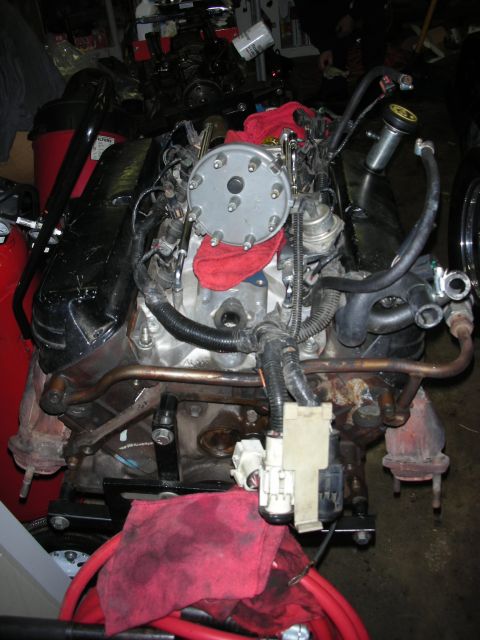 1990 Ford Mustang - Engine assembly with distributor cap, wiring, and exhaust manifold components.