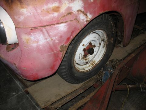 1952 Ford Pickup - Close-up of a 1952 Ford Pickup's front fender and wheel, with visible rust.