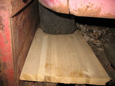 1952 Ford Pickup - A close-up view of a vehicle's fender and tire, supported by a wooden plank.