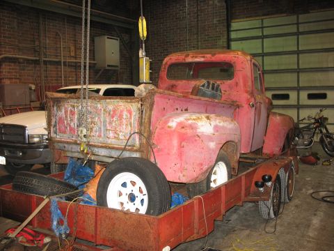 1952 Ford Pickup - A weathered 1952 Ford Pickup truck is seen on a trailer in a garage.