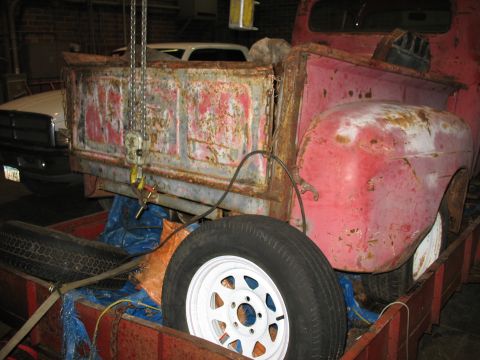 1952 Ford Pickup - Rear view of a weathered 1952 Ford Pickup truck, showing its bed and fender. A second vehicle is parked behind.