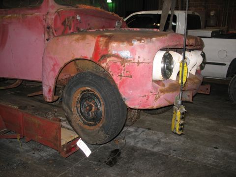 1952 Ford Pickup - This 1952 Ford Pickup is seen from the front 3/4 angle, showing its red, weathered body.