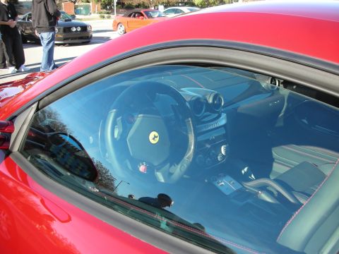 1998 Ford Crown Victoria - Looking through the side window of a red Ferrari at its steering wheel and dashboard with the prancing-horse on the wheel.