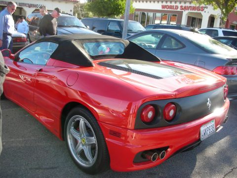 1998 Ford Crown Victoria - red Ferrari 360 Spider with black soft top, twin round taillights and California plate sits in a busy parking lot.