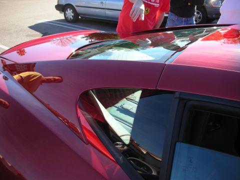 1998 Ford Crown Victoria - Detail of a dark red Ferrari's roofline, sail panel and rear quarter window in a parking lot.