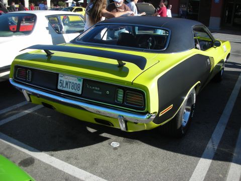 1998 Ford Crown Victoria - Rear three-quarter view of a lime-green and black Plymouth Cuda with vinyl roof and a California license plate.
