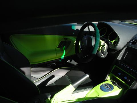 1998 Ford Crown Victoria - Sunlit interior of a Lamborghini showing green leather accents, a suede-rimmed wheel and a chrome gated shifter.